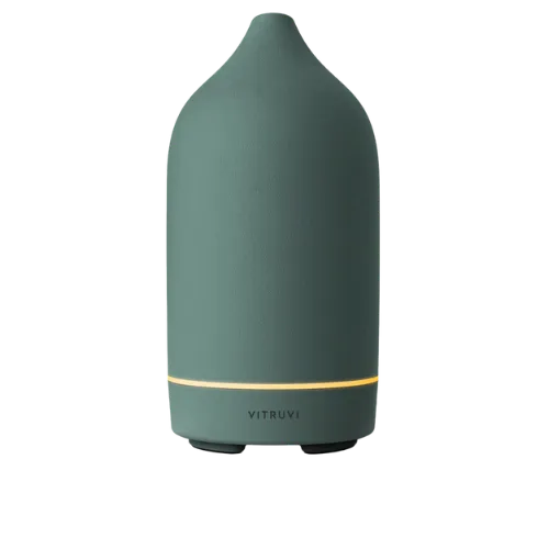 Teal Vitruvi essential oil diffuser with gold accent band and dark base