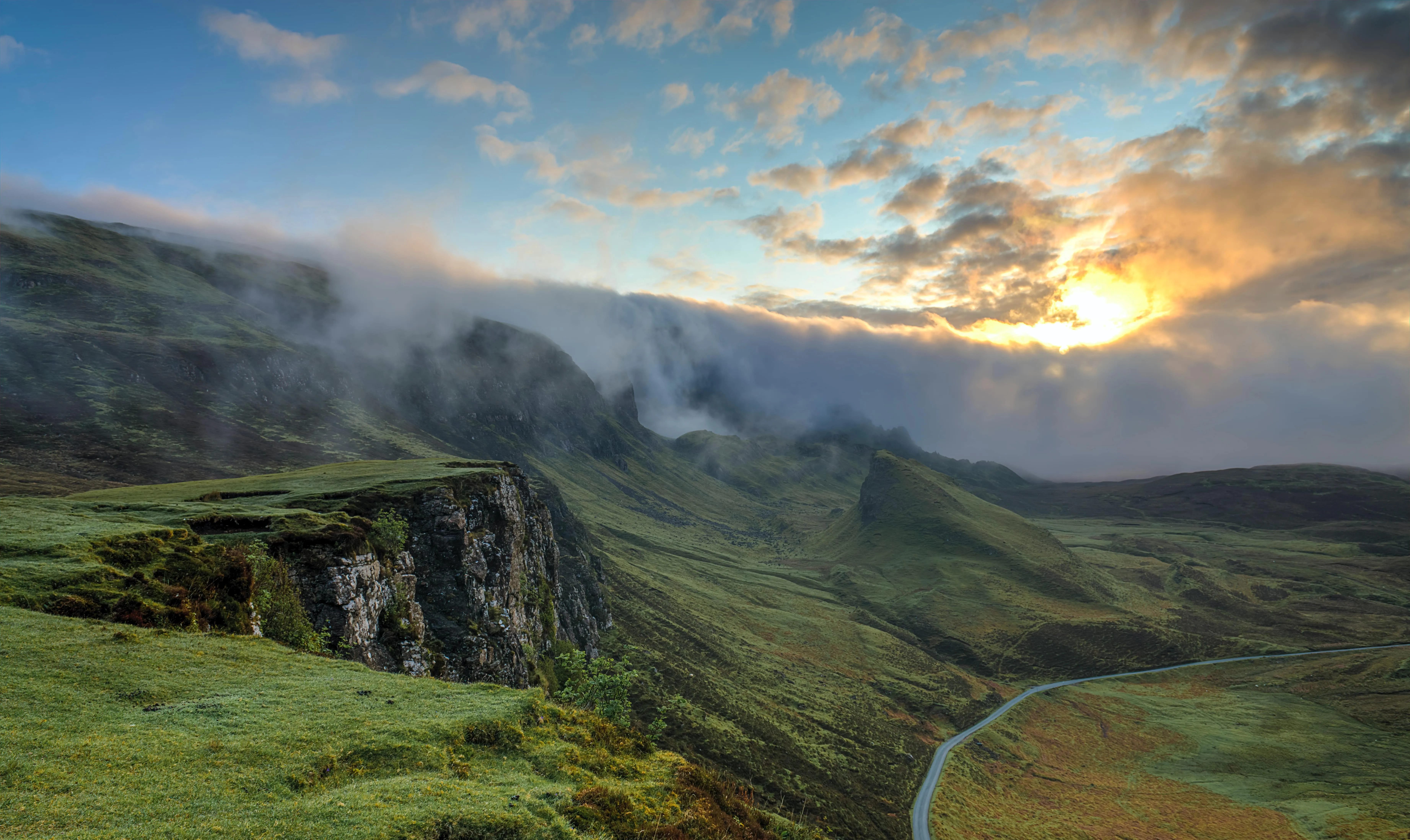 a scenic view of a mountain with a winding road in the foreground