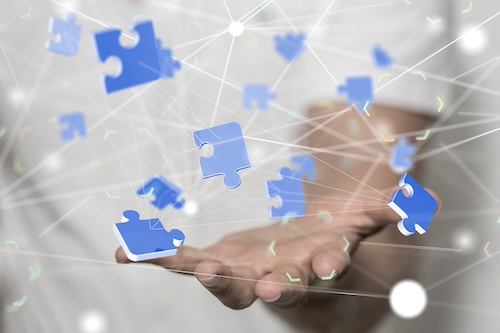 Hand mit Puzzleteilen als Symbol für flexible IT-Lösungen und Integration