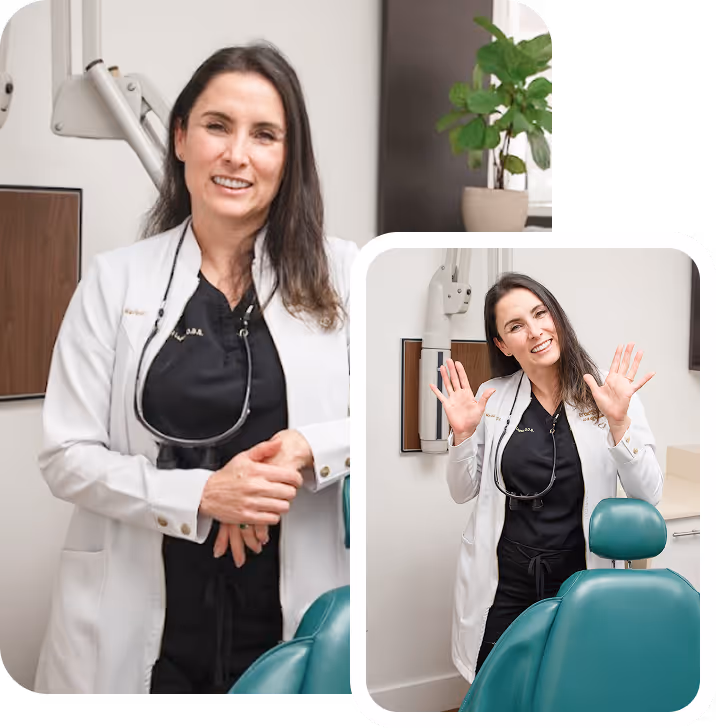 Female dentist wearing a white coat and black scrubs standing beside a dental chair in a clinic, smiling and raising both hands.