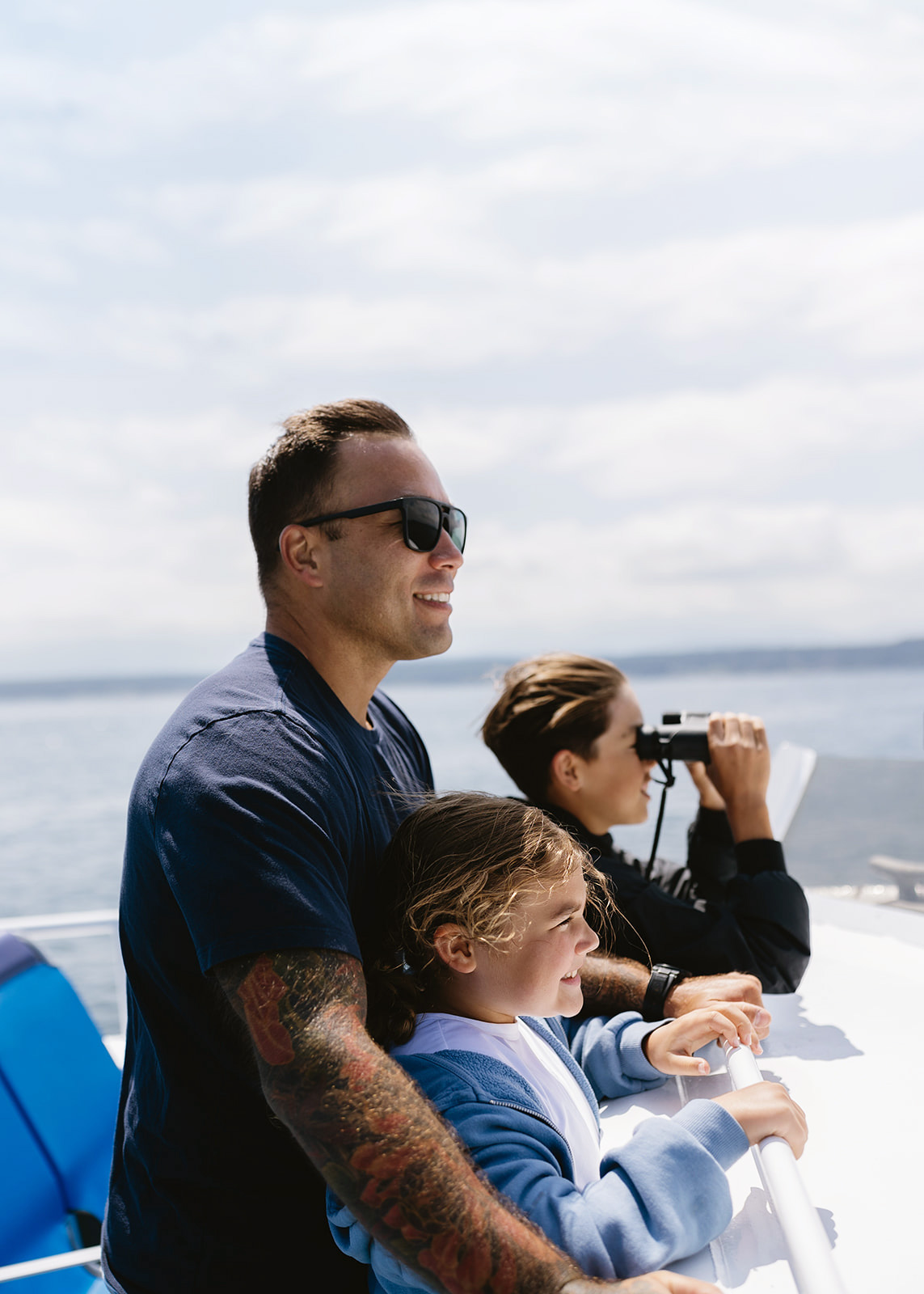 Dad and two kids whale watching on a boat