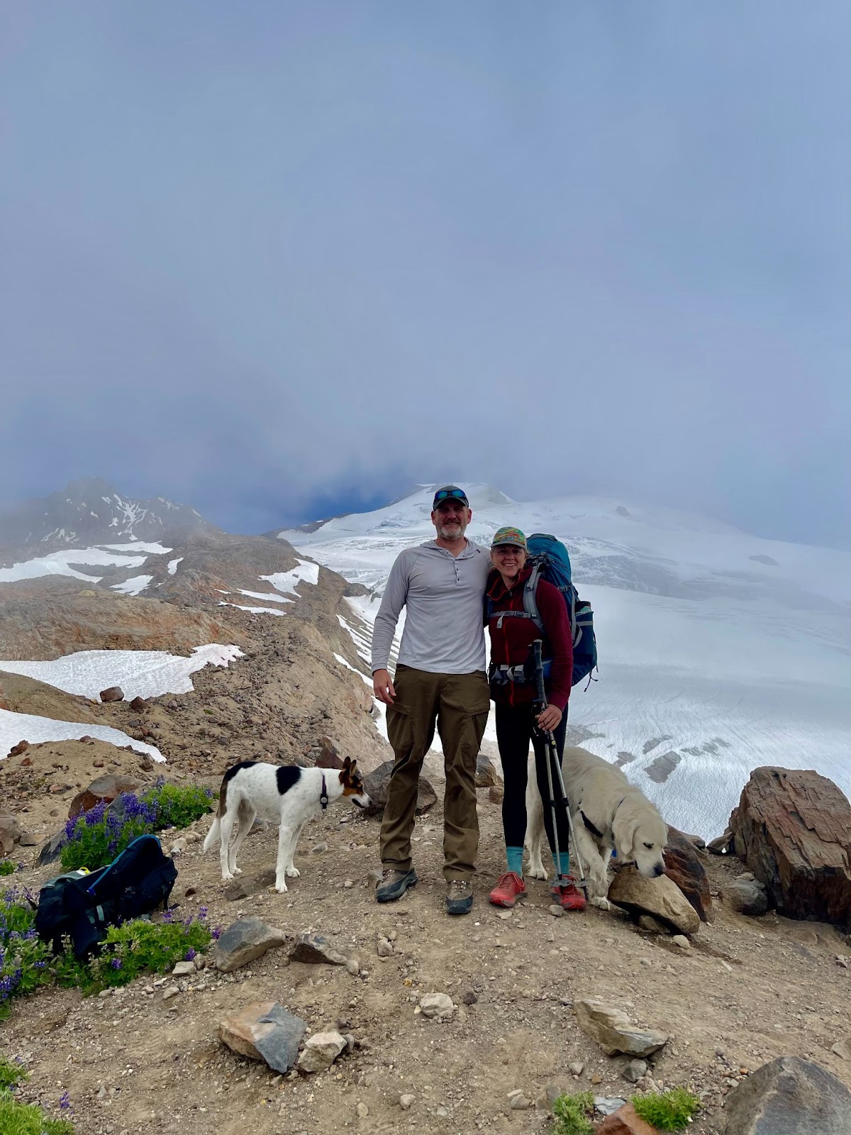 Man and woman standing at the foot of a glacier