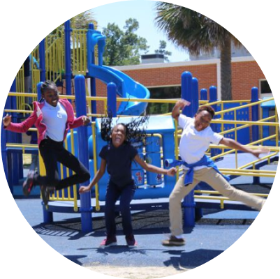 Young students jumping into a pose on a playground