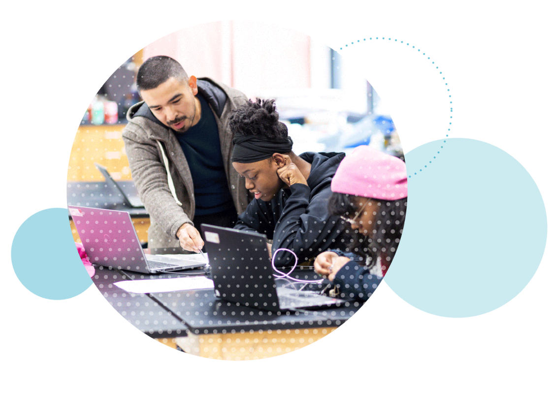 Young man helping a student while she is on a computer