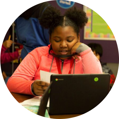 Young student reading a paper in front of a tablet 