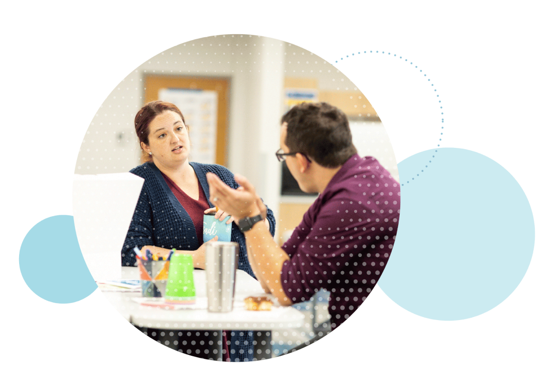 Teammates in conversation at work table