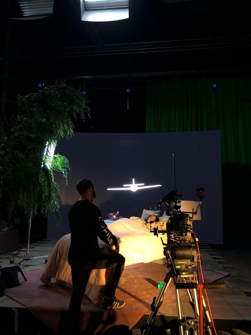 Our Virtual Production Process - 003 Tech-Vis and Pre-Vis
An image on set with a CoPilot Crew Member and talent for a small ICVFX demo project. An LED Wall featuring the CoPilot Brandmark Plane sits as a temporary backdrop in front of a child's bedroom set decoration.
The scene is darkly lit with motivated lighting illuminating the subject on-set as camera tests and technical tests are performed.