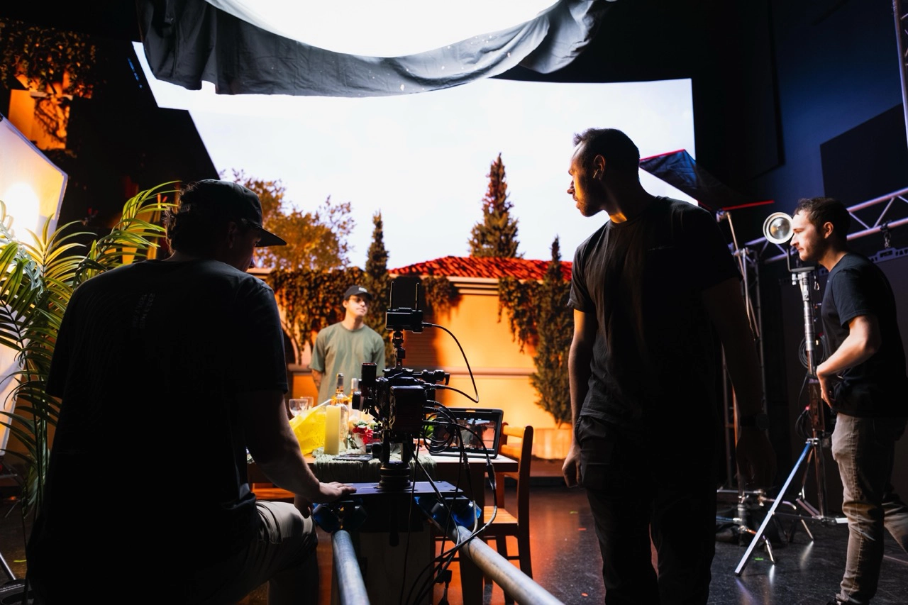 Decorative. 

Description: crew members on stage in front of an illuminated LED Wall reviewing shots and camera actions on set.