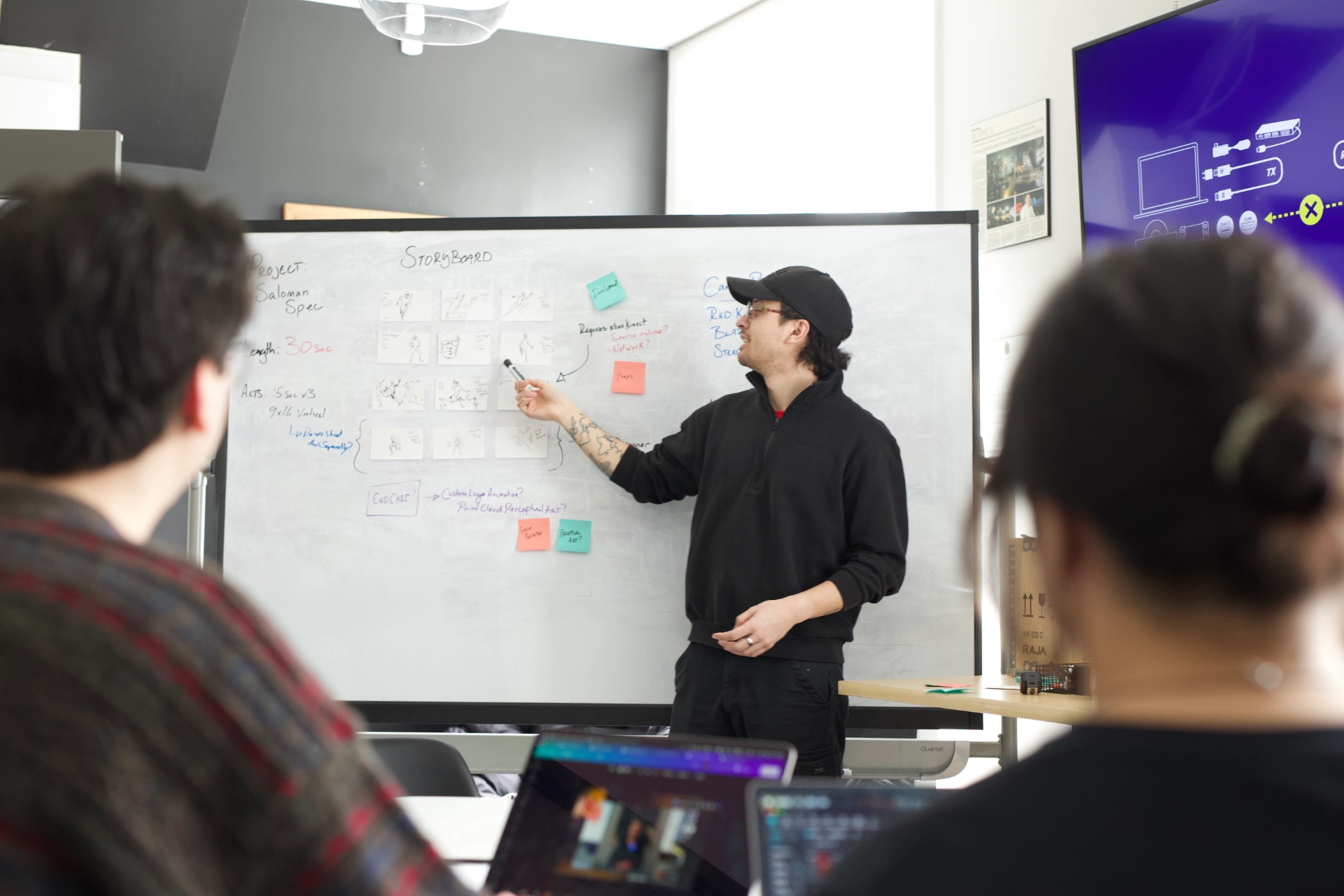 Decorative

Description: An Instructor stands in front of a white board with two students framing the foreground