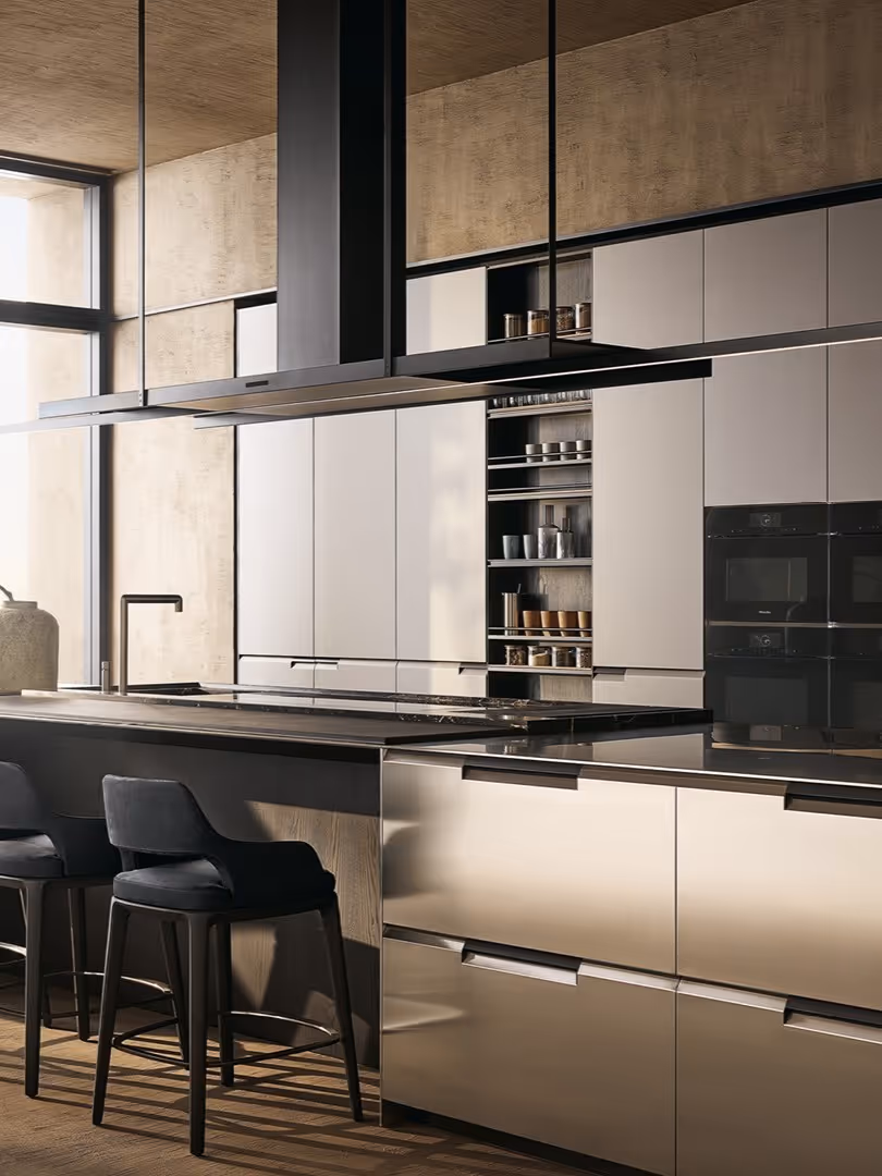 Modern kitchen with matte beige cabinets, black bar stools, and a black island countertop under suspended range hoods.