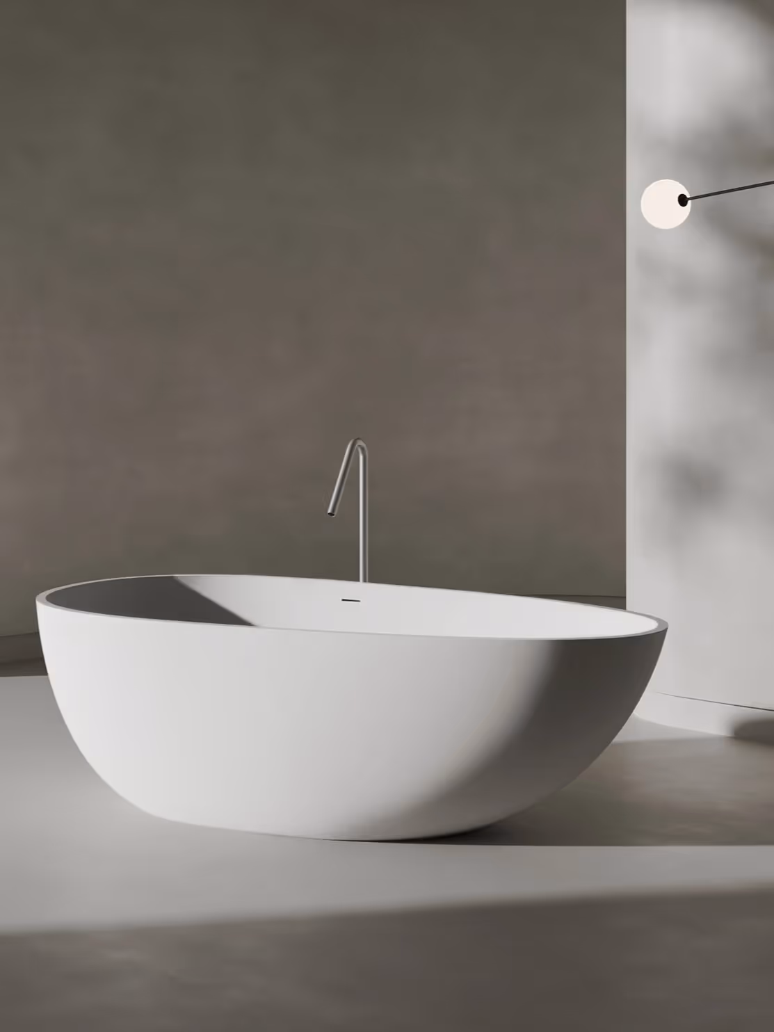 Minimalist white oval freestanding bathtub in a modern bathroom with soft natural lighting.
