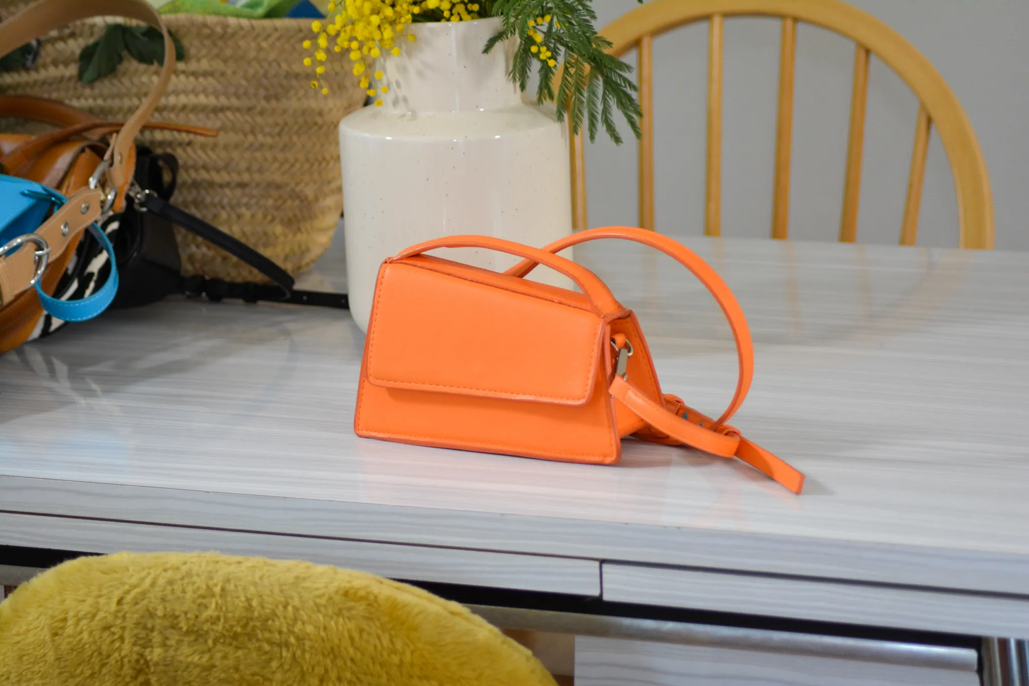 Le sac à main orange chiné par Clémence posé sur la table de sa salle à manger