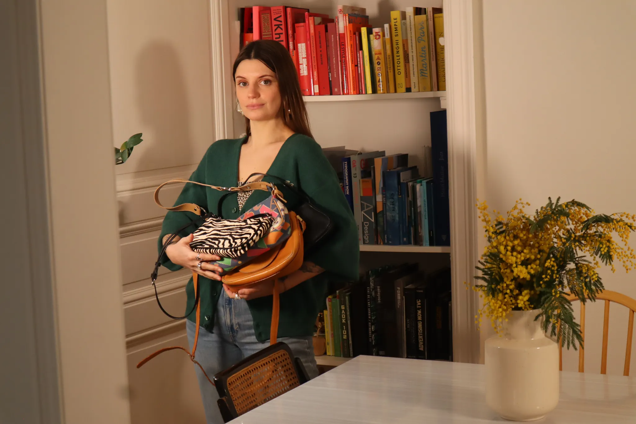 Clémence posant avec en main ses sacs à main de seconde main