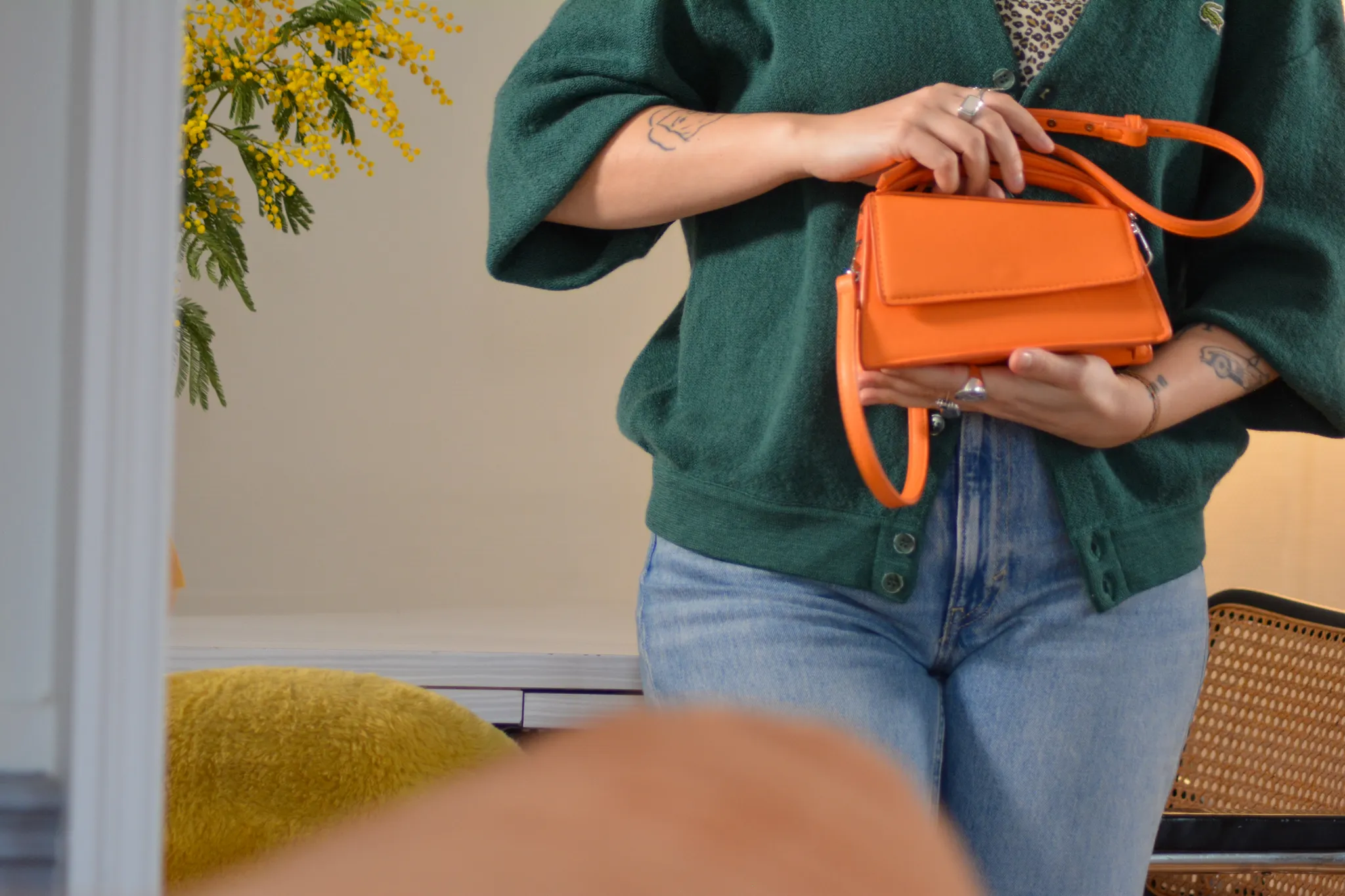 Clémence tenant en main un sac à main de couleur orange acheté sur Vinted