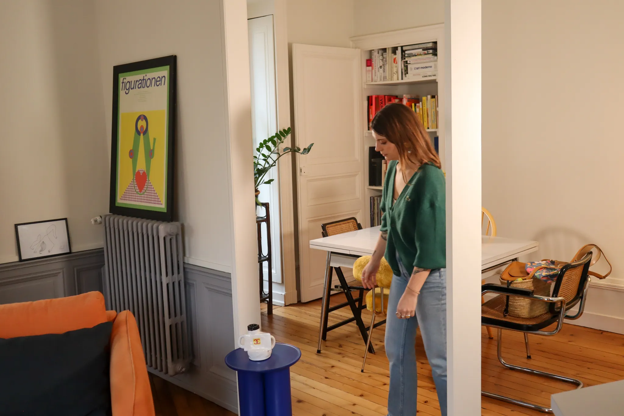 Clémence marchant dans son salon au milieu de meubles et objets chinés 