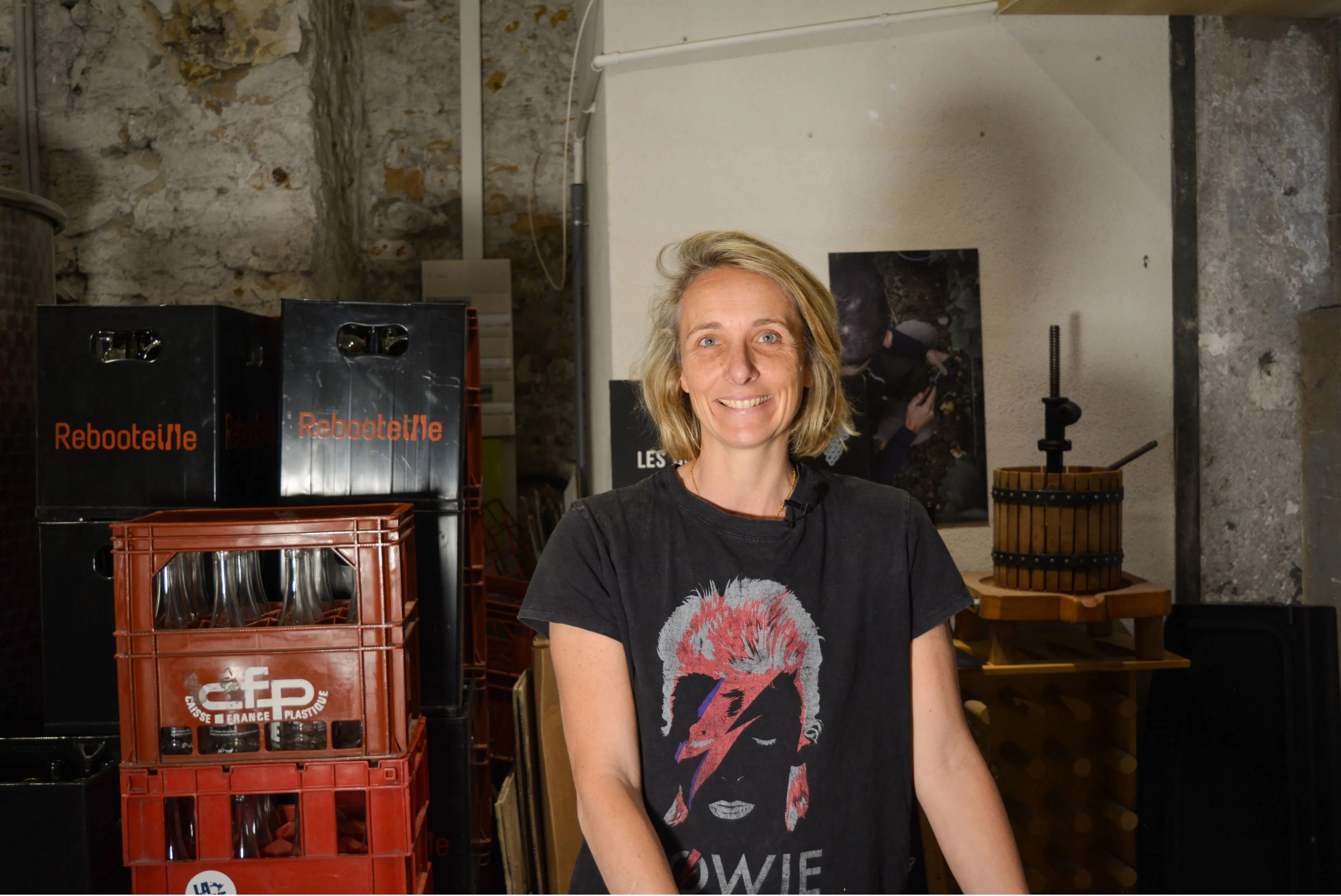 Géraldine qui pose à côté d'un fut avec les caisses Reboosteille pour la consigne en arrière plan