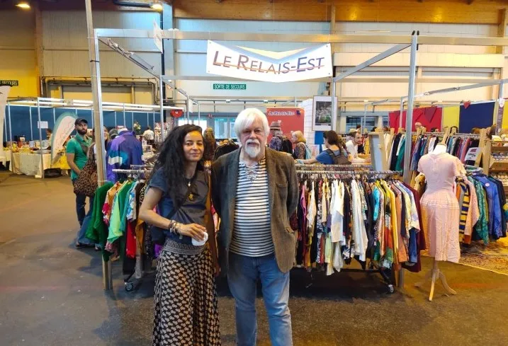 Paul Watson soutient le réemploi solidaire sur le stand Relais Est, entouré de vêtements seconde main à la Foire Éco Bio de Colmar.