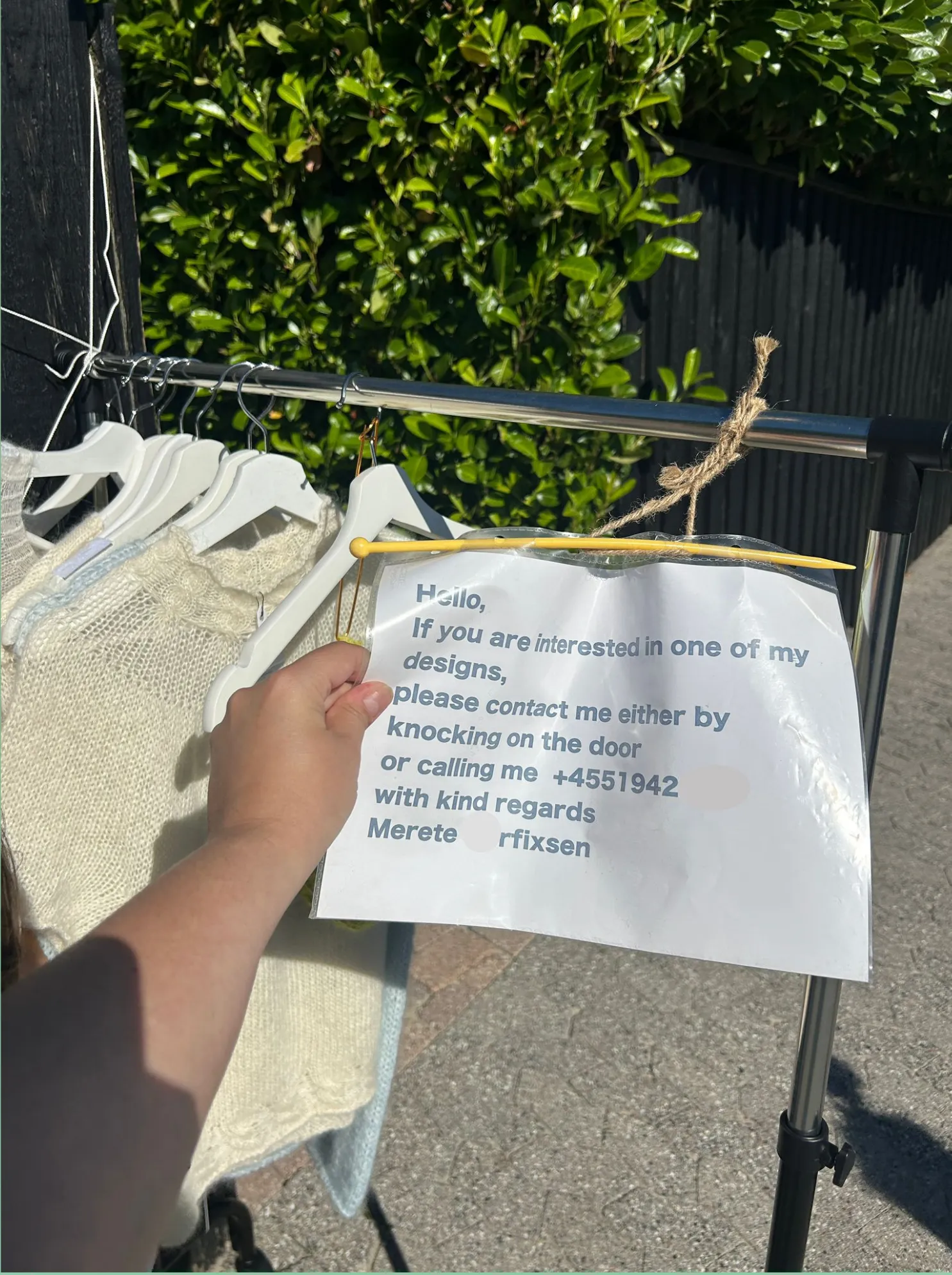 À Copenhague, un panneau manuscrit invite à contacter la créatrice pour acheter ses tricots exposés en libre-service, symbole de la seconde main de confiance.