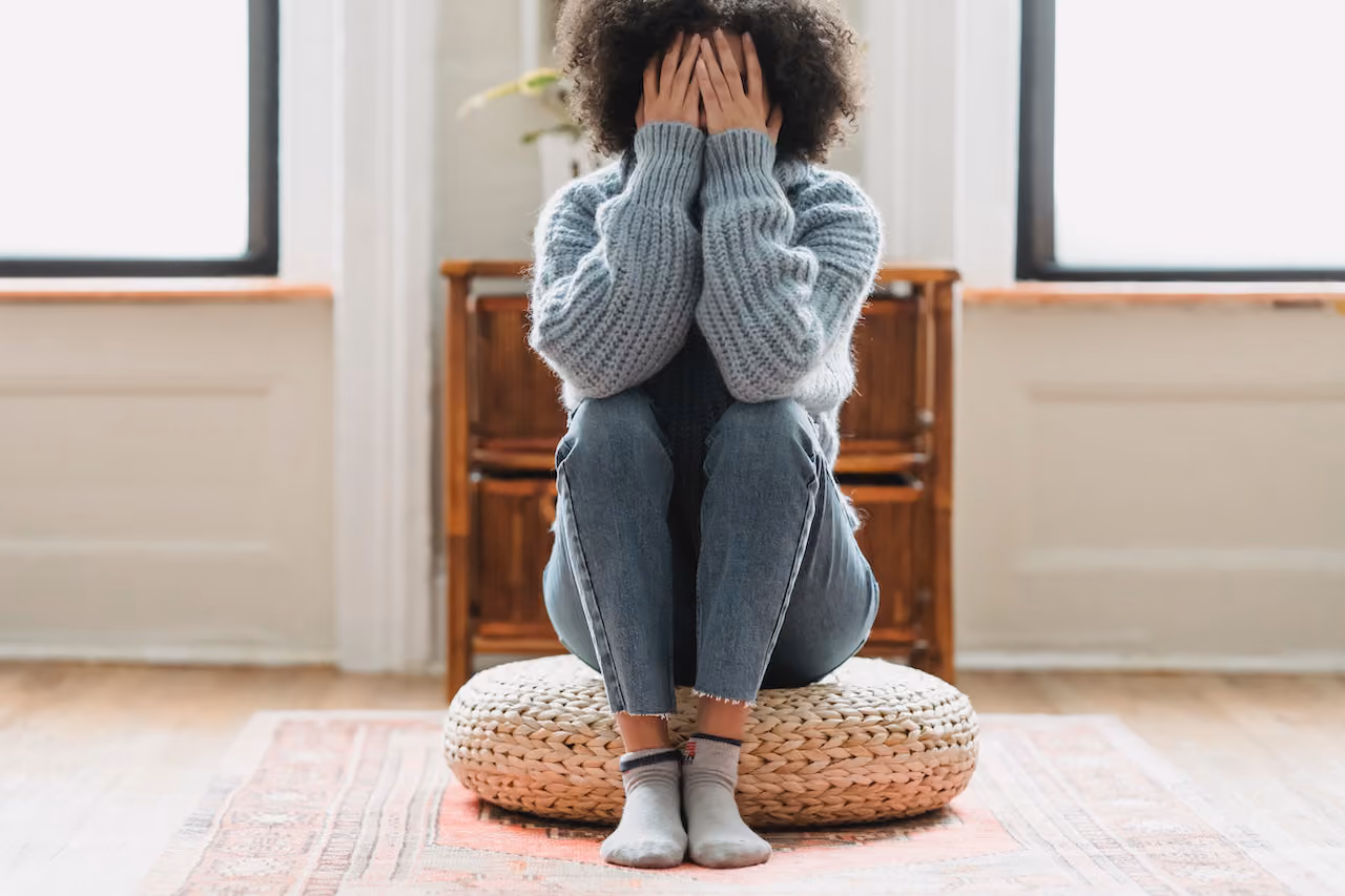 Young woman with her head in her hands, struggling with a major life challenge.