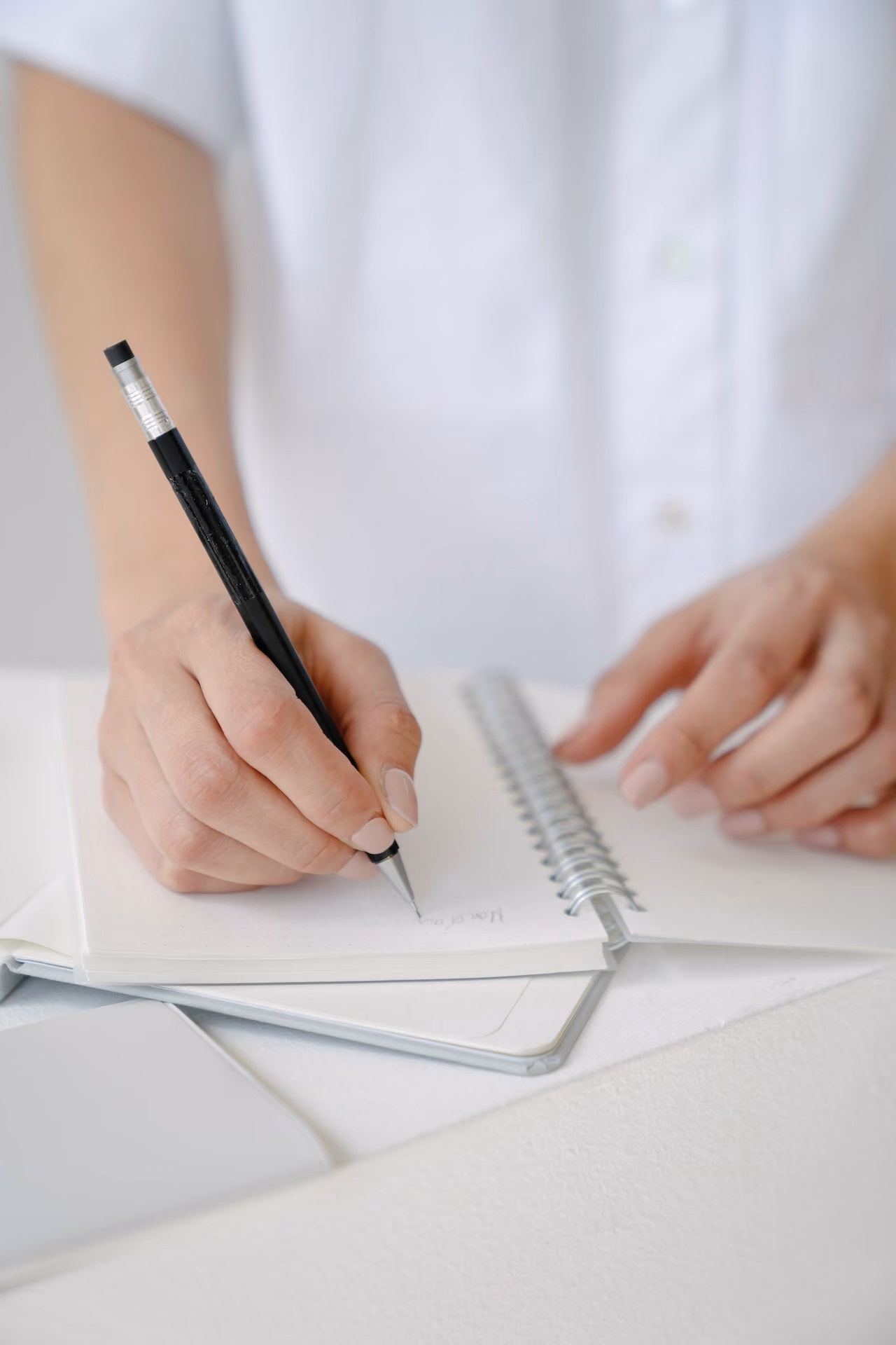 Therapist writing down notes while talking with a client.