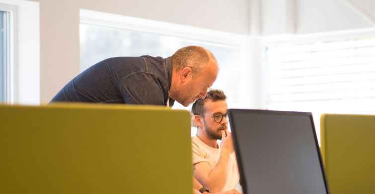 Two people working at a flex desk
