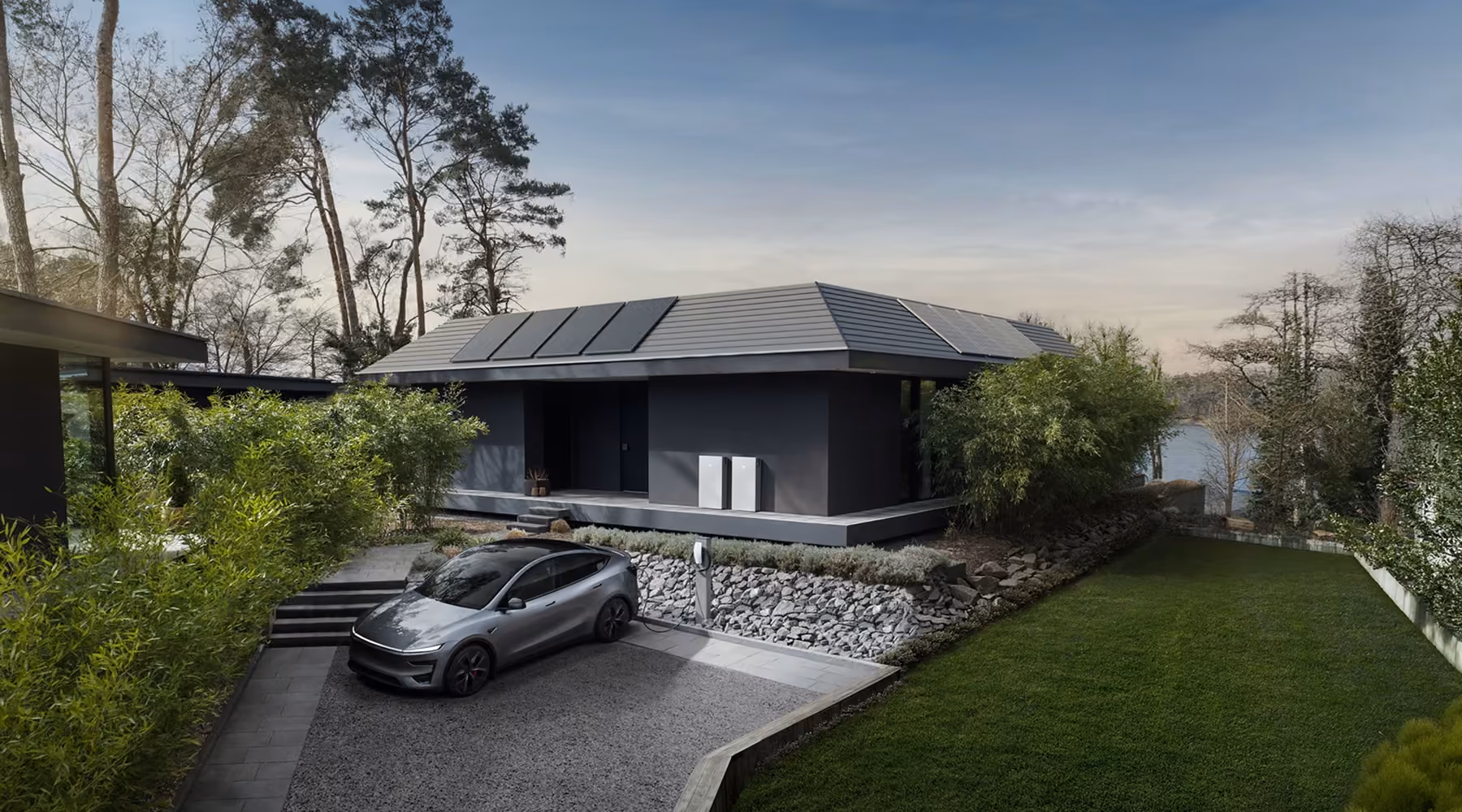 Moderne woning met zonnepanelen, Tesla Powerwalls en elektrische auto aan de laadpaal