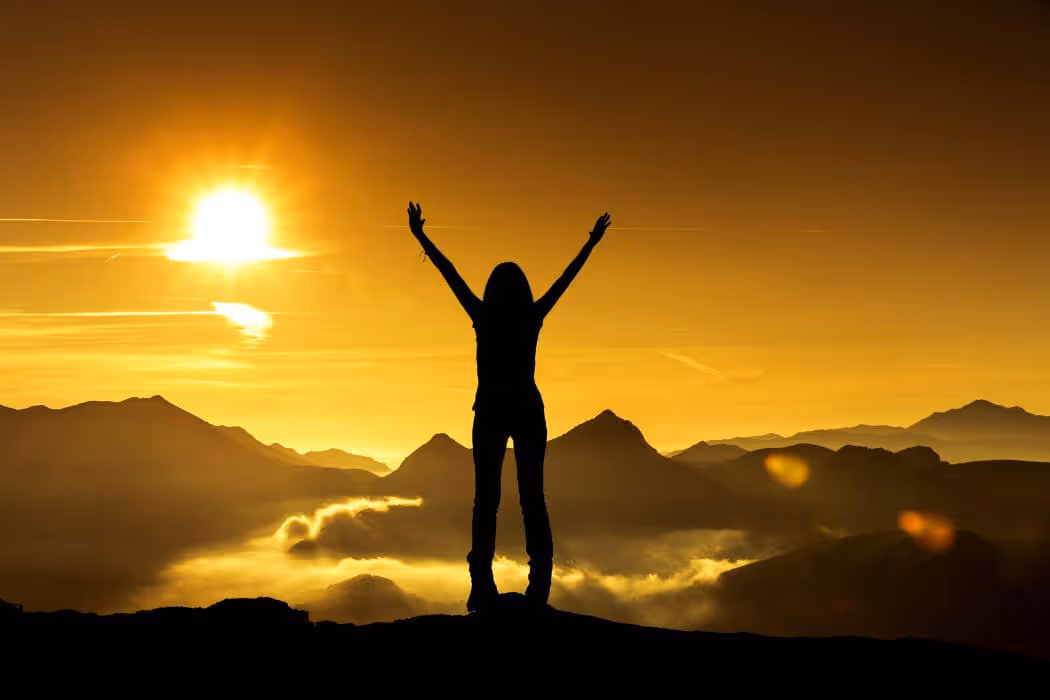 Standing on top of mountain with hands raised