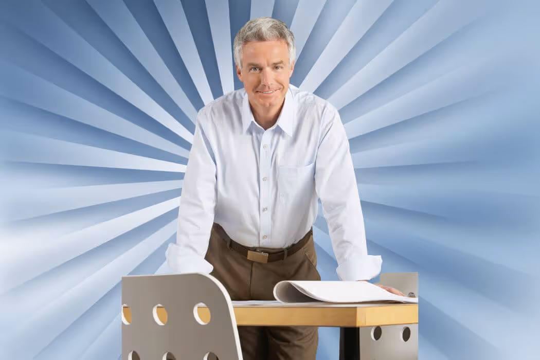 Man standing and leaning forward on desk