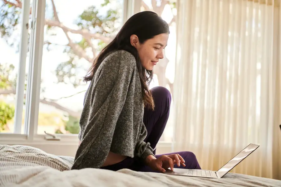 Young woman joining a virtual visit on her laptop at home