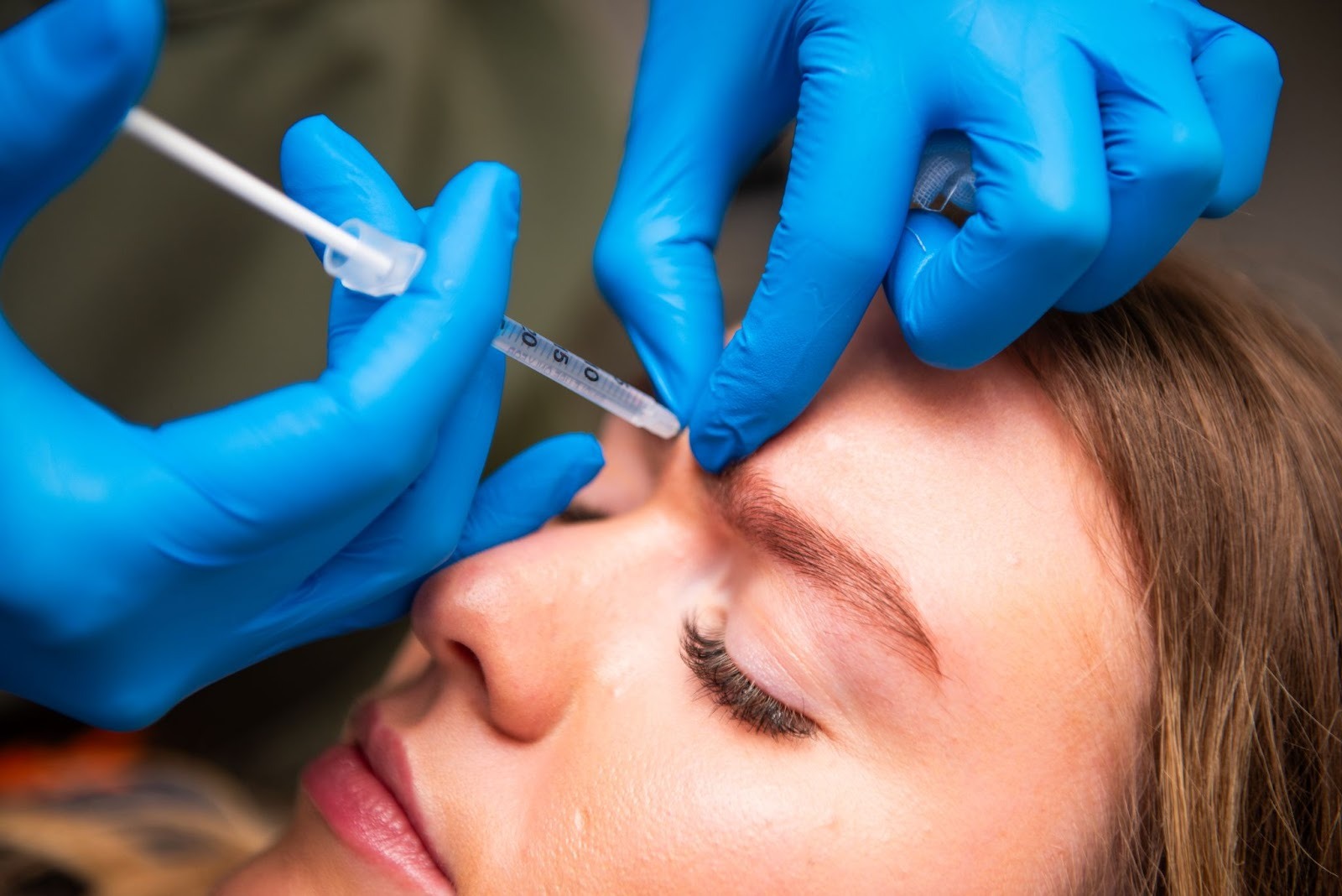 Clinician at Feel Good Dental in Croydon applying a safe anti wrinkle treatment to a woman's forehead