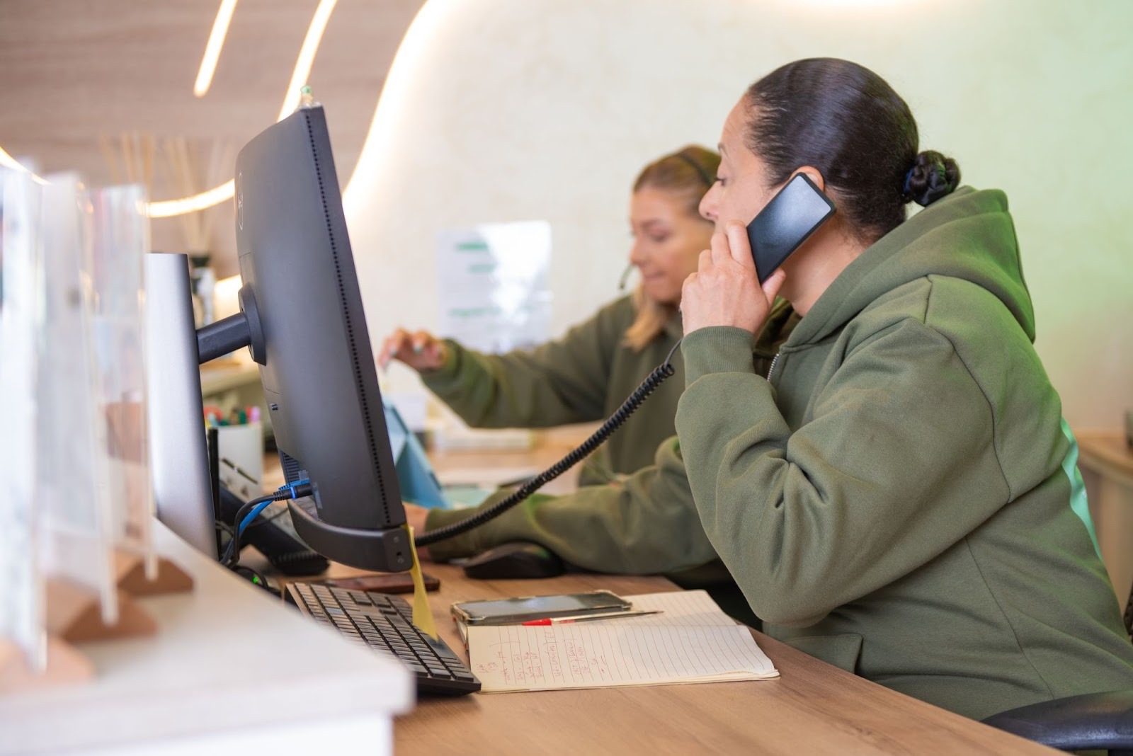 Treatment co-ordinators Eli and Stacey at Feel Good Dental  speaking on phone arranging urgent emergency dentist appointment in Croydon