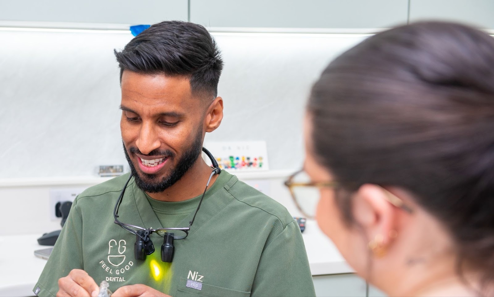 Dentist Dr Niz at Feel Good Dental Croydon discussing crown treatment options with patient