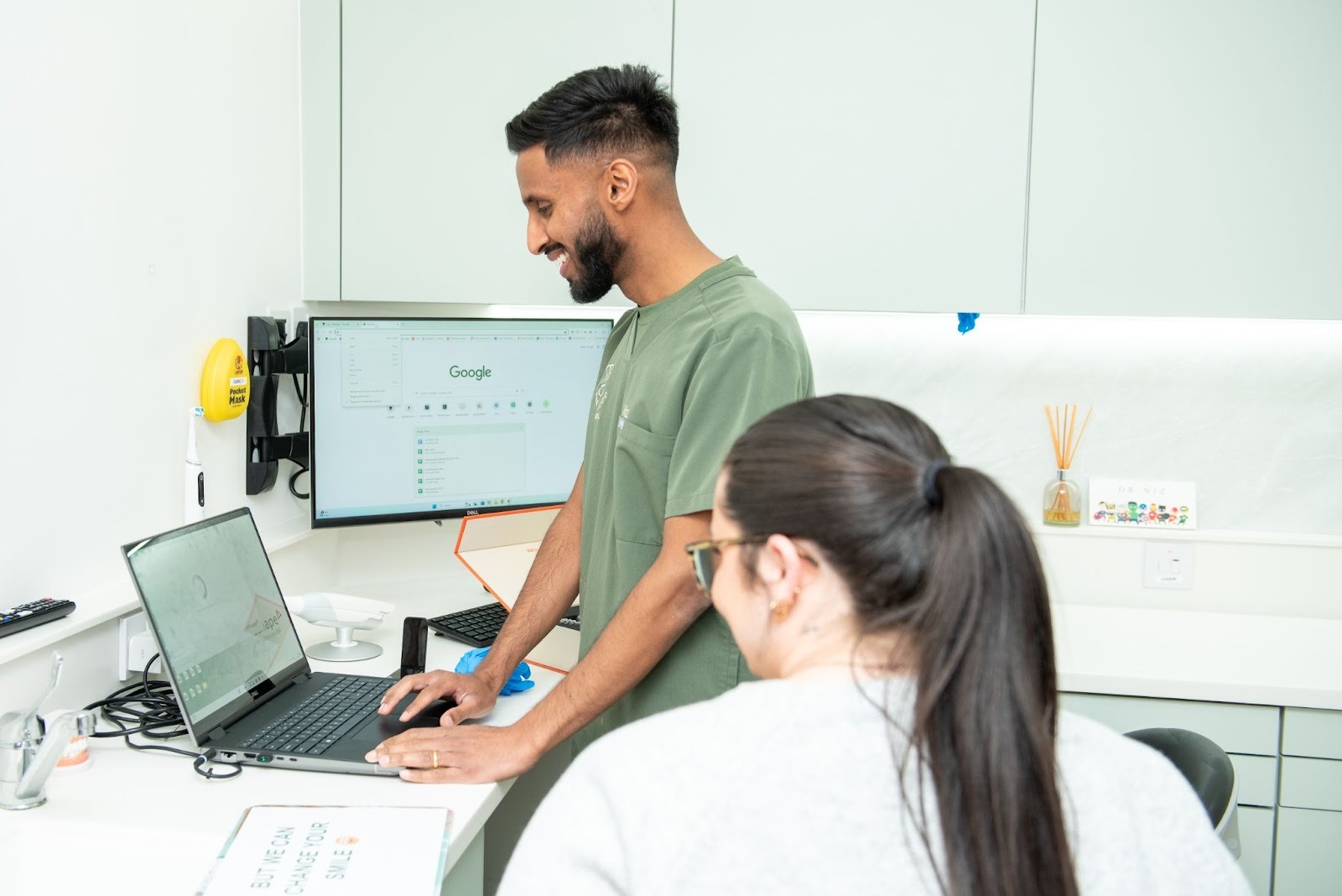 Principal dentist Dr Niz discussing dental implant treatment plan with patient during consultation in Croydon dental practice