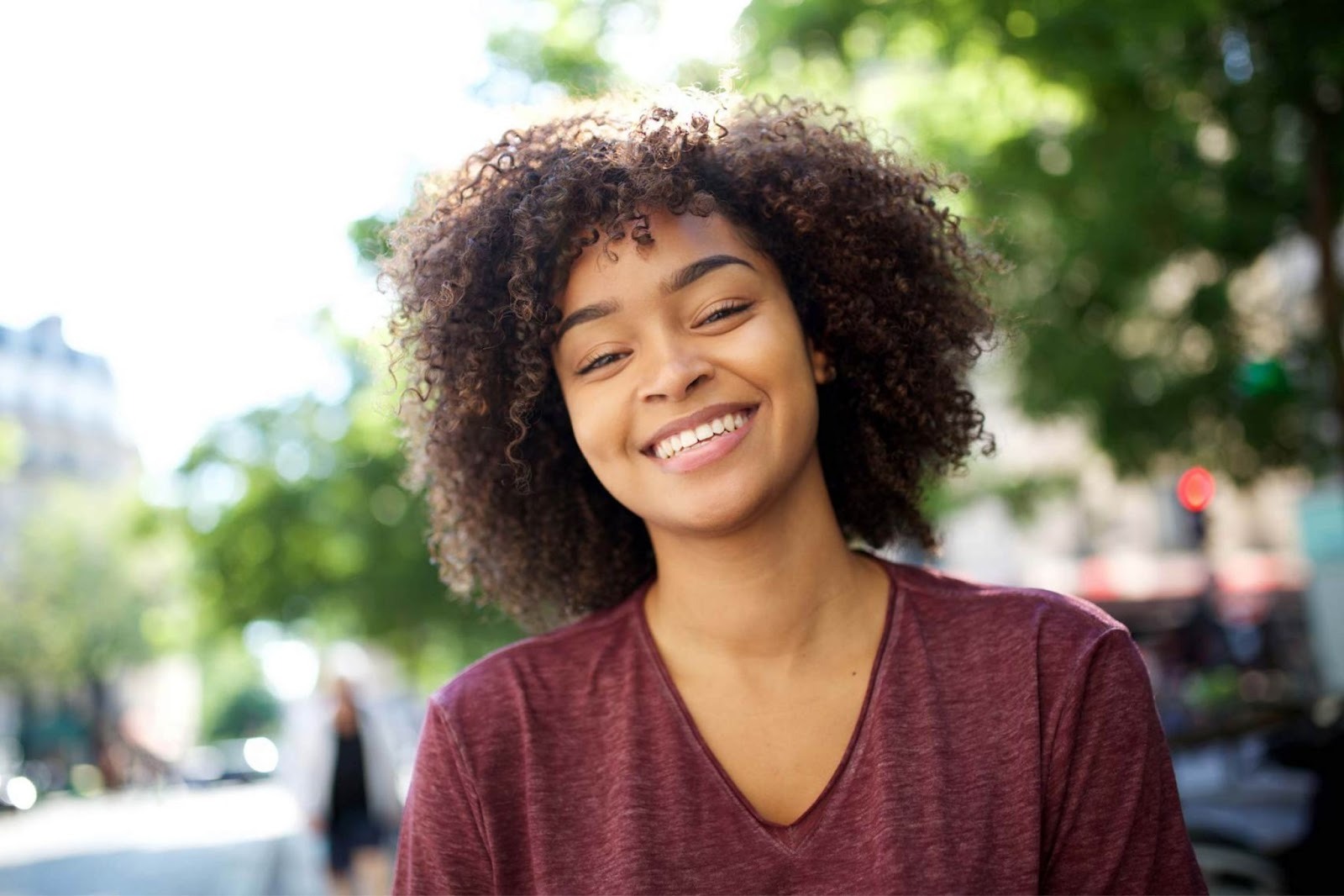 Young woman smiling confidently outdoors after improving her smile with cosmetic dentistry in West Croydon