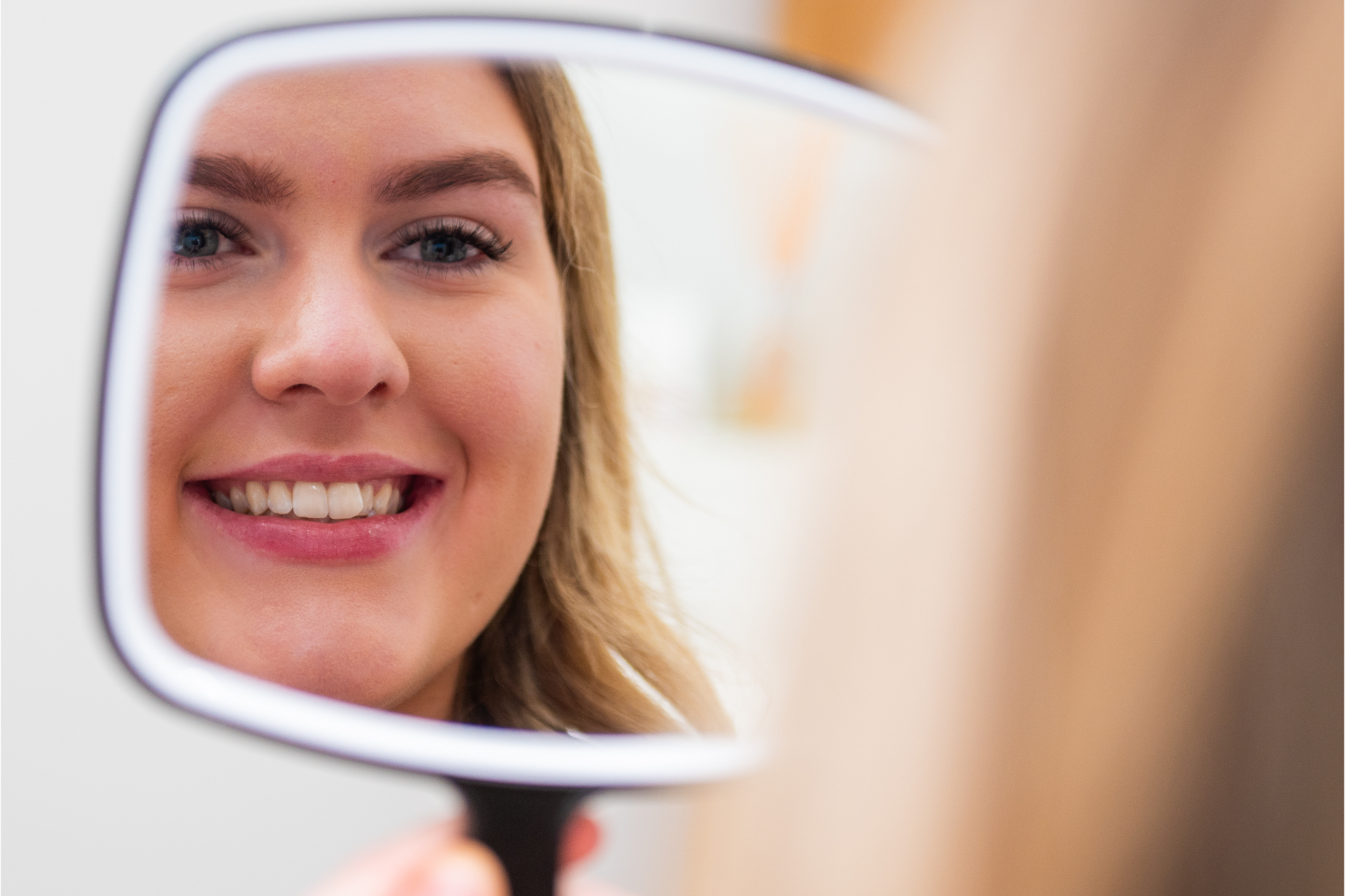 Patient checking brighter smile after professional teeth whitening treatment in Croydon