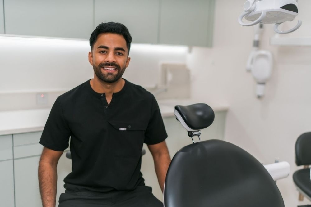 Dr Nev Jeyakumar, specialist implant dentist at Feel Good Dental Croydon, discussing dental implant treatment with a patient