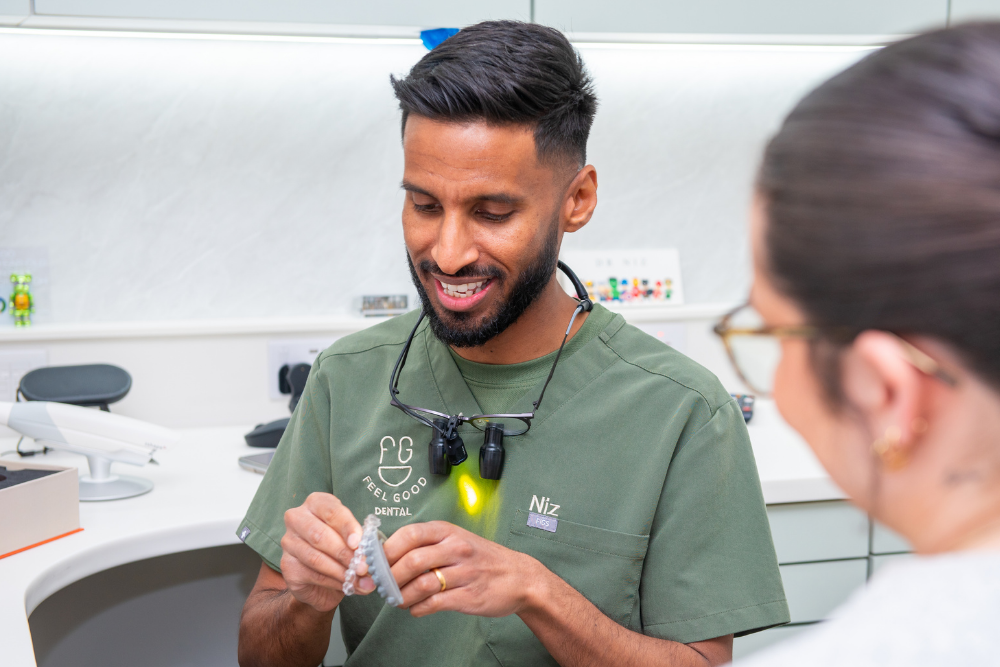 Feel Good Dental dentist Niz discussing Invisalign clear aligners with a patient in Croydon