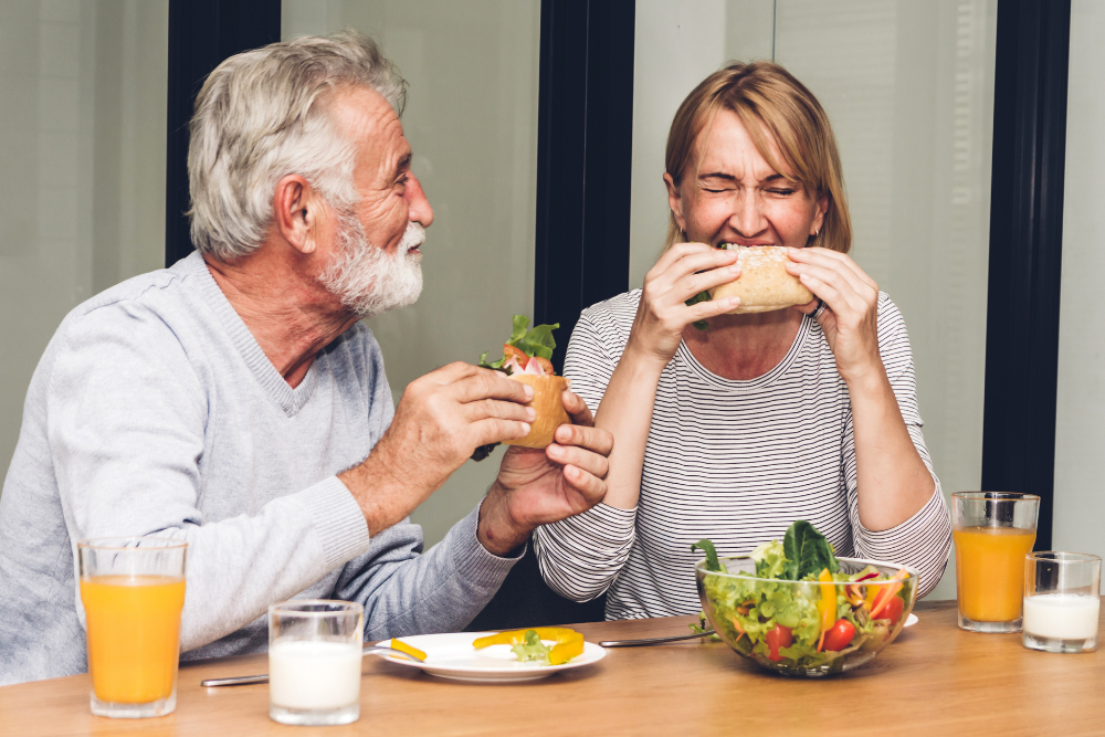 Couple enjoying a meal with secure replacement teeth after tooth loss