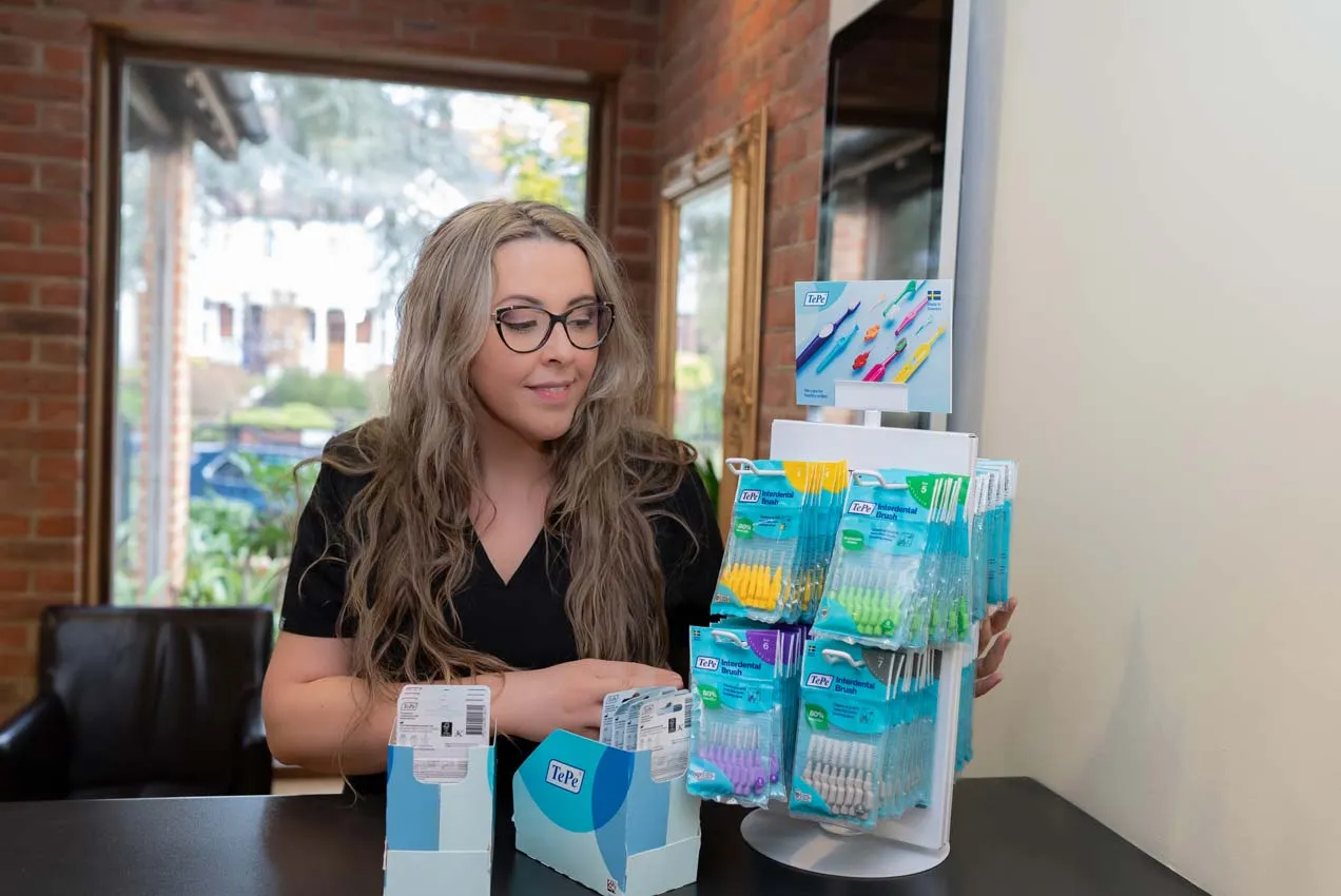 Dental hygienist at Foxley Lane Dental in Purley showing children’s toothbrushes and oral care products, helping families across Croydon, Wallington, Coulsdon and surrounding areas prevent tooth decay.