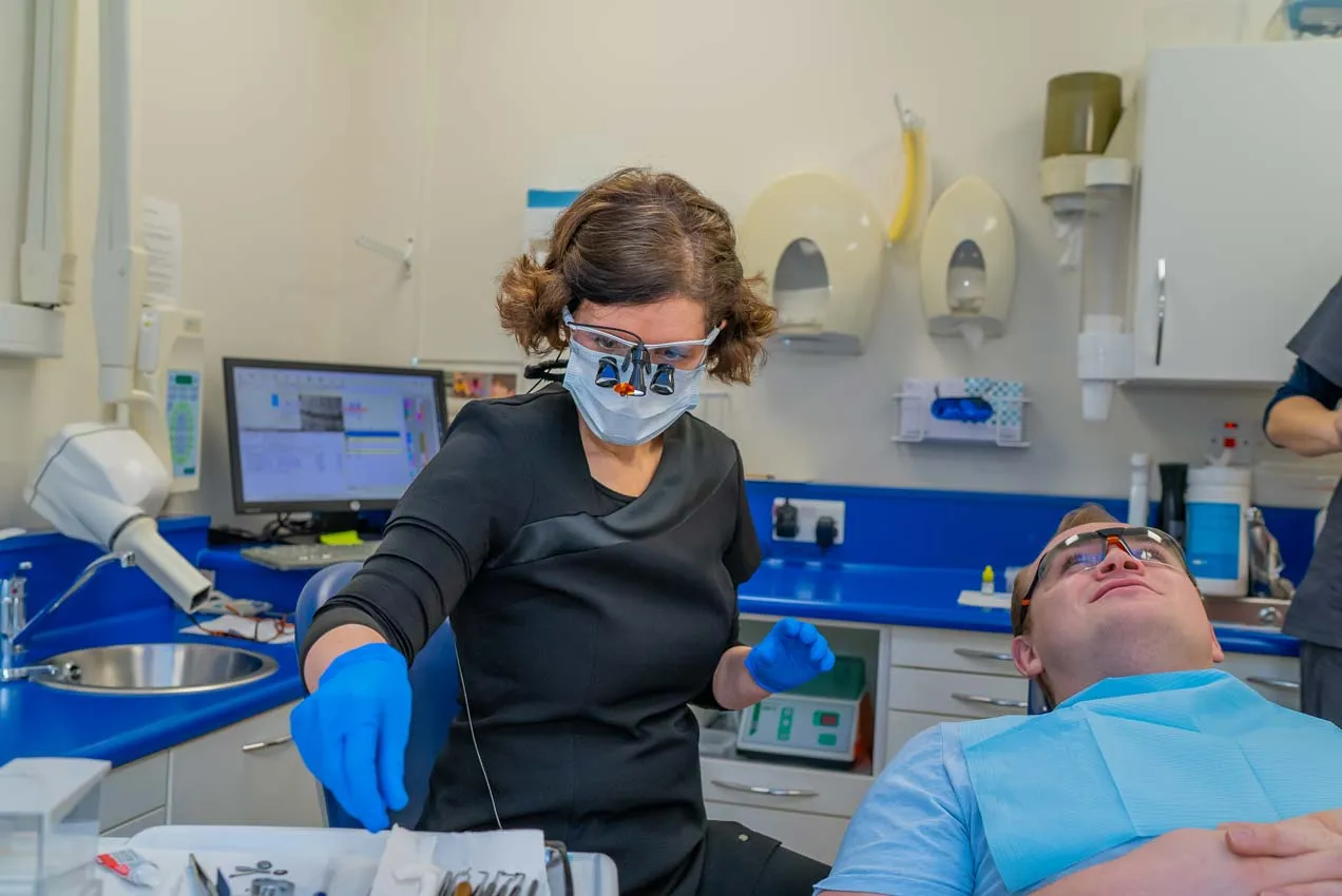 Specialist endodontist carrying out root canal treatment to remove infection and preserve a natural tooth.