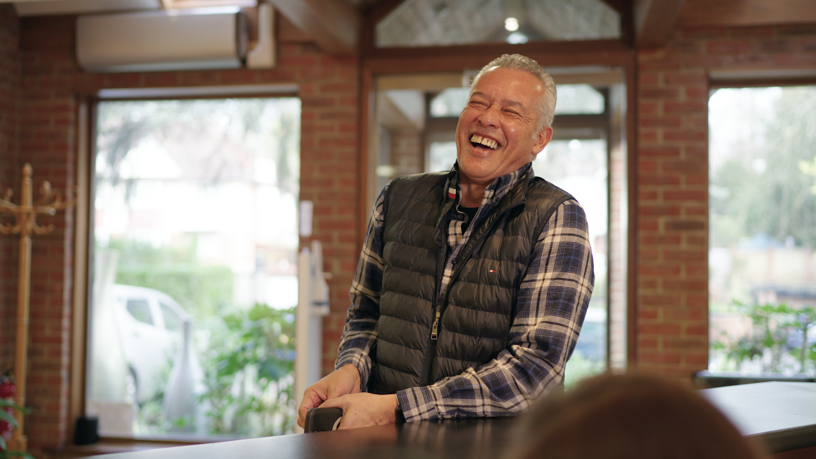 A smiling older customer in the reception area awaiting his dental check-up appointment.