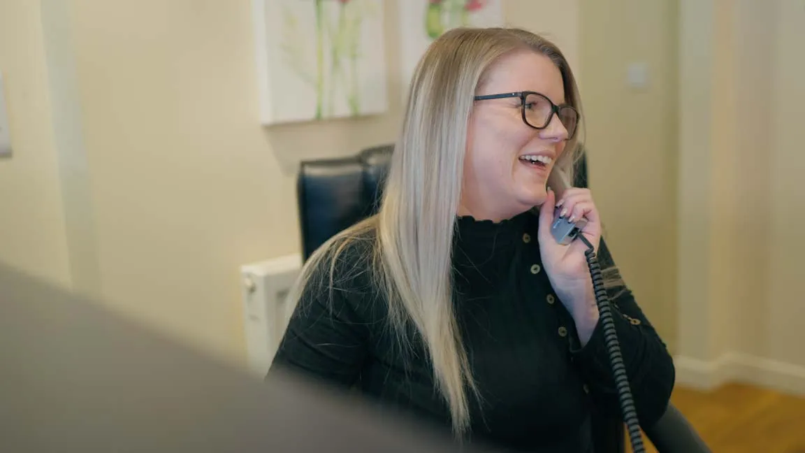Friendly receptionist at Foxley Lane Dental speaking on the phone, welcoming patients to the family dental practice in Purley