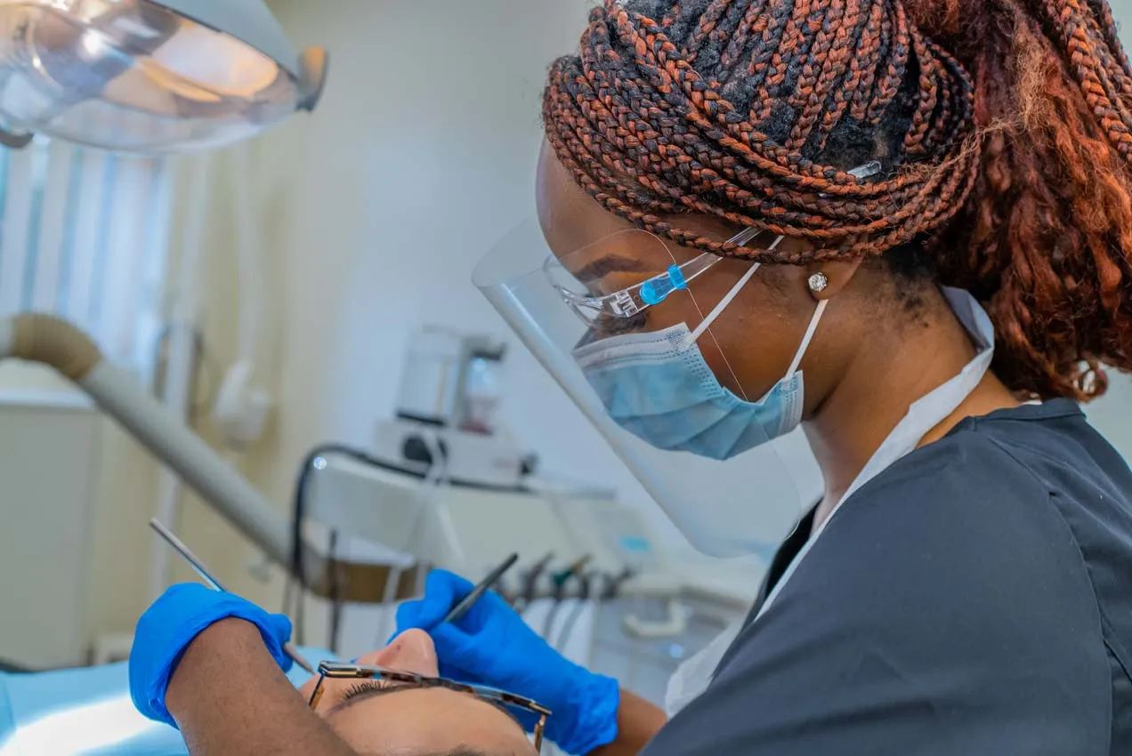 Dental hygienist treating a patient at Foxley Lane Dental in Purley, using PPE for safe and professional family dentistry