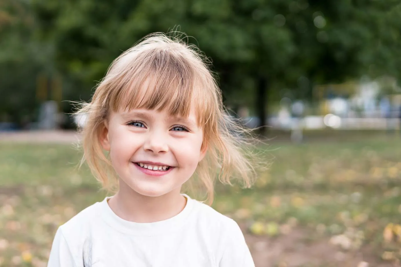 Smiling young girl outdoors, benefitting from free NHS dental treatment for children under 18 at Foxley Lane Dental in Purley