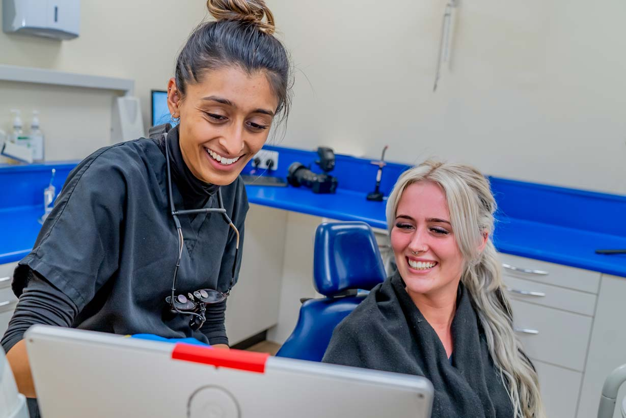 The principal dentist at Foxley Lane Dental in Purley showing a patient her treatment plan on screen during a consultation. The image captures the welcoming, supportive atmosphere of the practice, where patients receive personalised care for cosmetic dentistry, composite bonding, veneers, dental implants and general treatments across Purley, Croydon, Addington and South London.