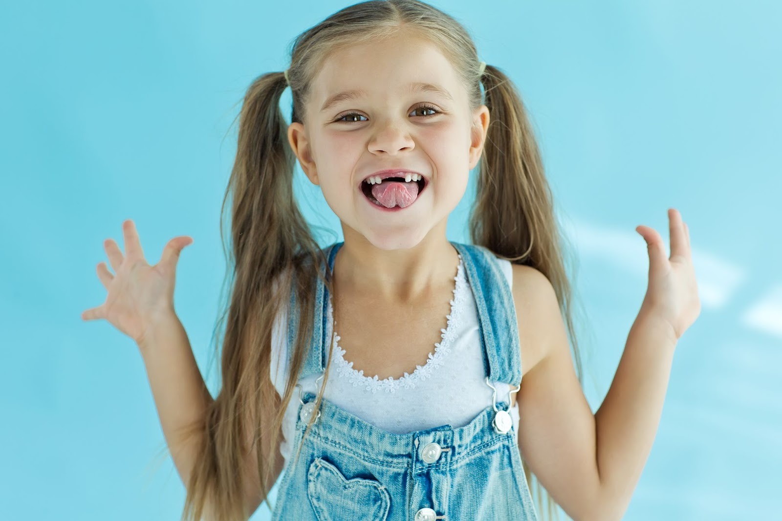 Young girl smiling with missing baby tooth, showing natural tooth loss compared to dental trauma
