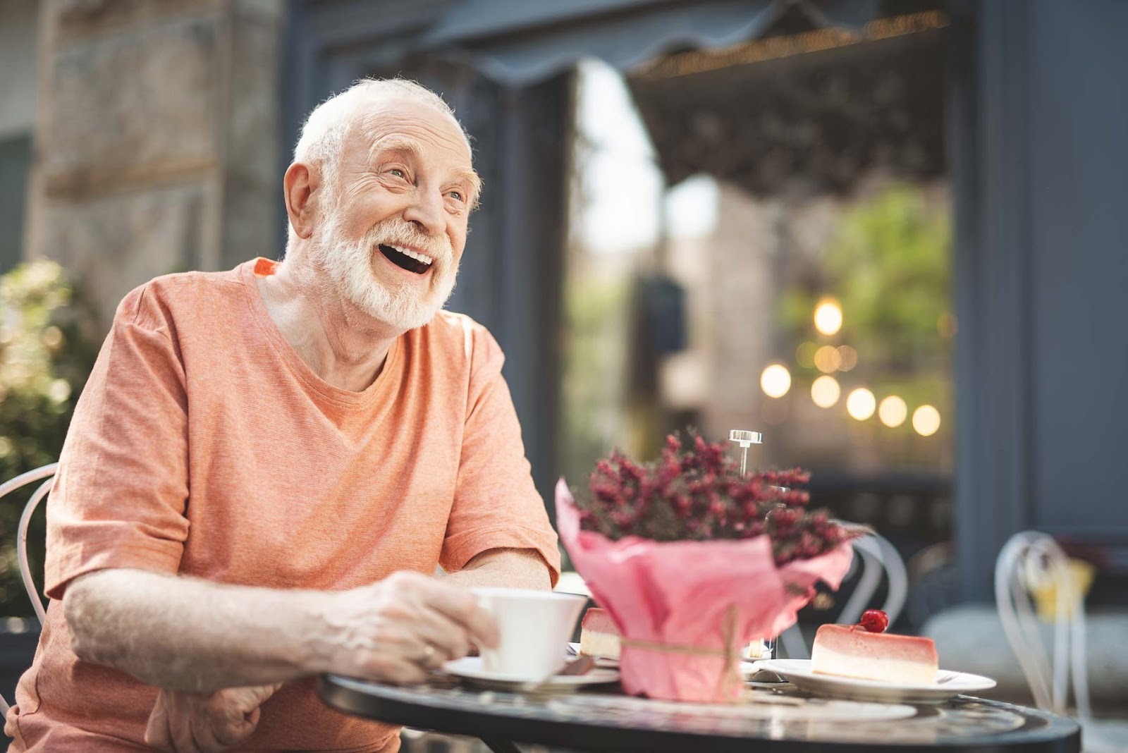 Older man smiling confidently while eating, reflecting stability and comfort after tooth replacement treatment
