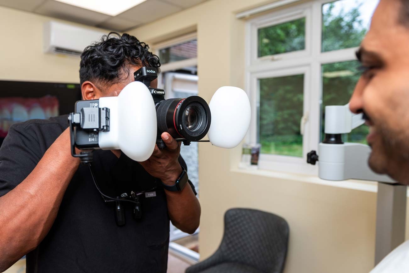 Dentist taking detailed photographs of a patient’s teeth for digital smile design planning