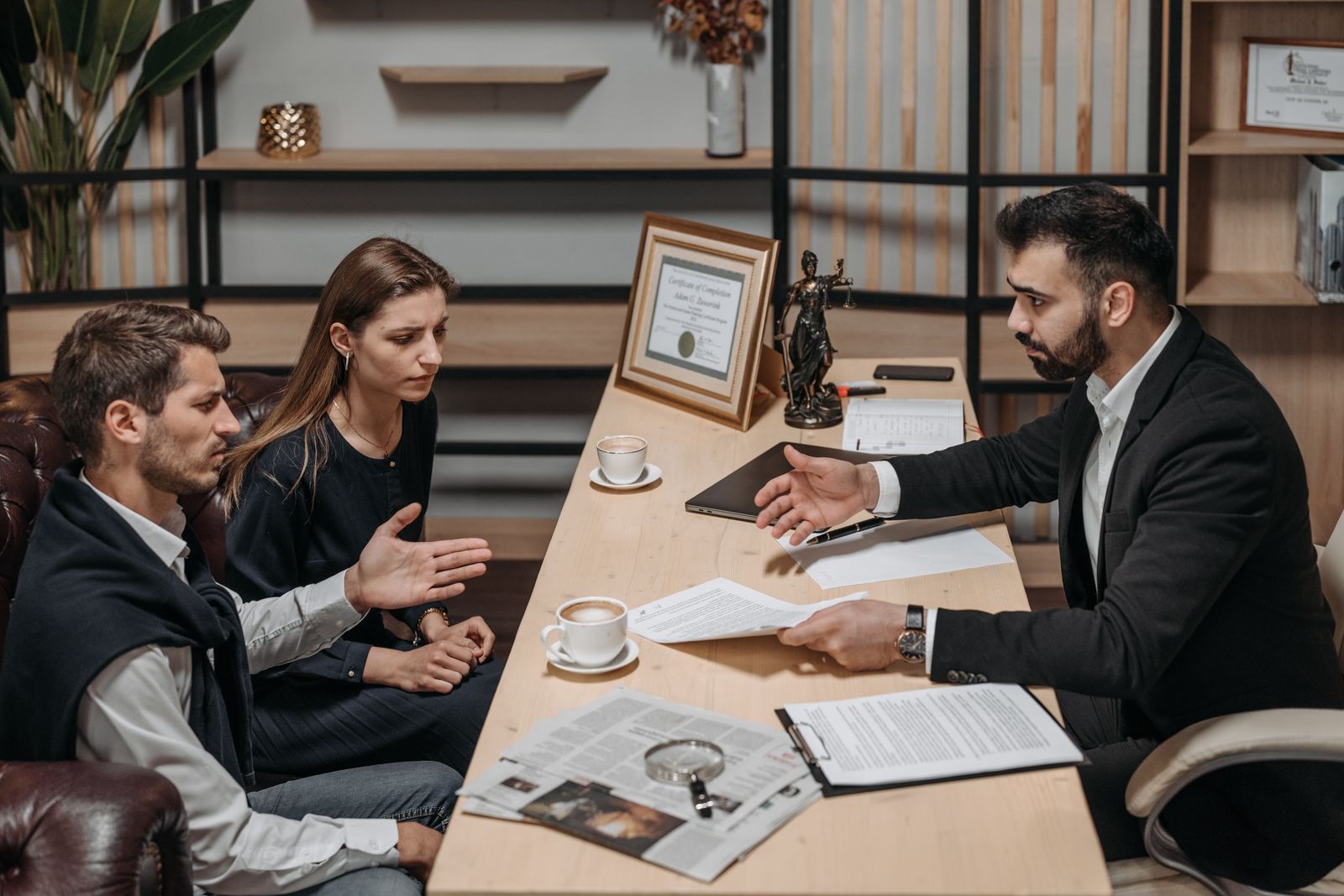 Attorney consulting with clients over legal documents in an office