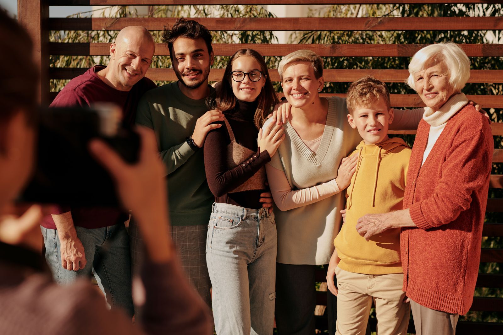 Three generations of a family smiling together outdoors